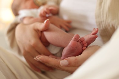 Photo of Mother with her newborn baby at home, closeup