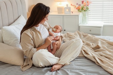 Photo of Mother with her newborn baby on bed at home