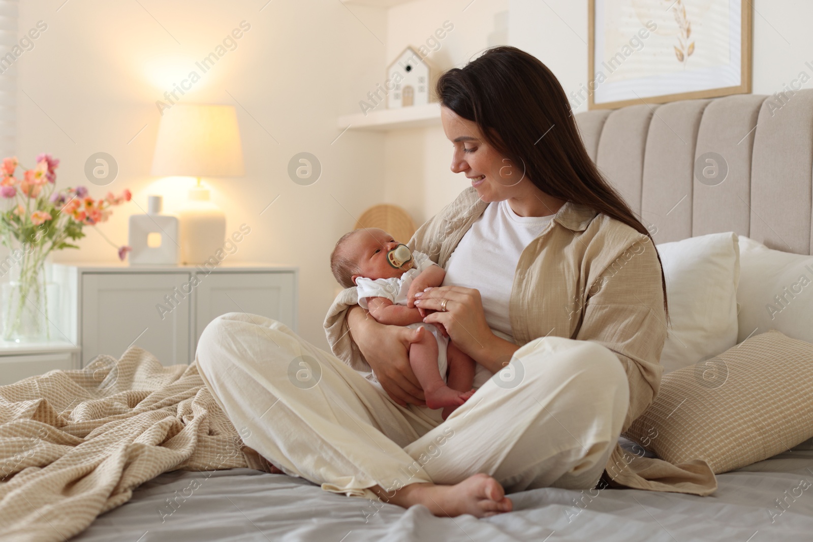 Mother with her newborn baby on bed at home Photo of Mother with her newborn baby on bed at home
