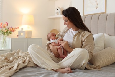 Photo of Mother with her newborn baby on bed at home