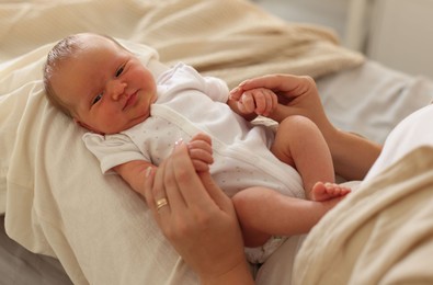 Photo of Mother with her newborn baby on bed at home, closeup
