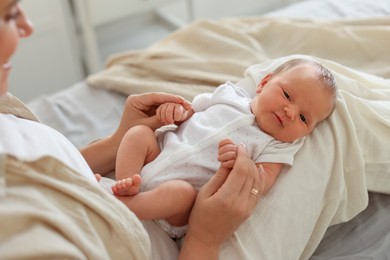Photo of Mother with her newborn baby on bed at home, closeup