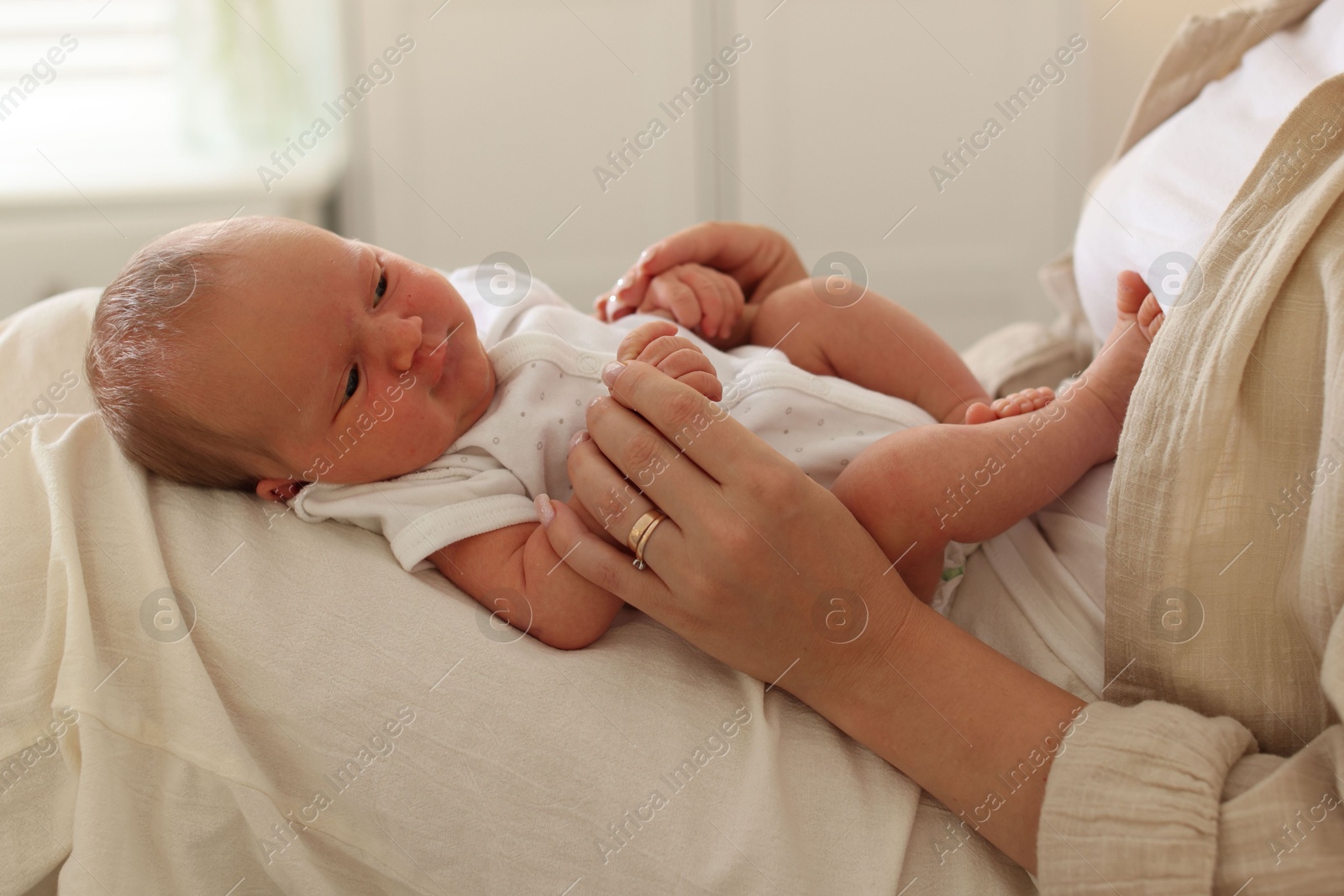 Mother with her newborn baby on bed at home, closeup Photo of Mother with her newborn baby on bed at home, closeup
