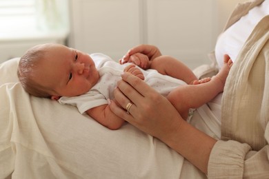 Photo of Mother with her newborn baby on bed at home, closeup