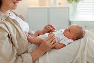 Photo of Mother with her newborn baby on bed at home, closeup