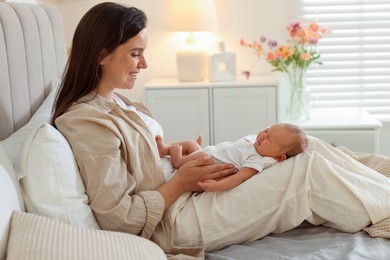 Photo of Mother with her newborn baby on bed at home. Space for text