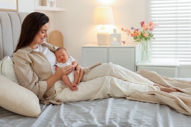 Photo of Mother with her newborn baby on bed at home. Space for text