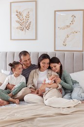 Photo of Happy family with newborn baby on bed at home