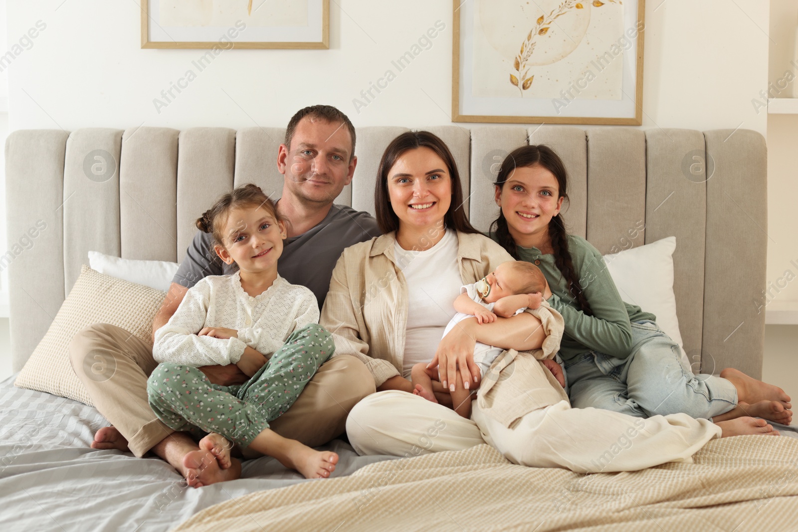 Happy family with newborn baby on bed at home Photo of Happy family with newborn baby on bed at home