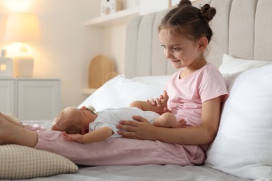 Photo of Big sister with newborn baby on bed at home. Space for text