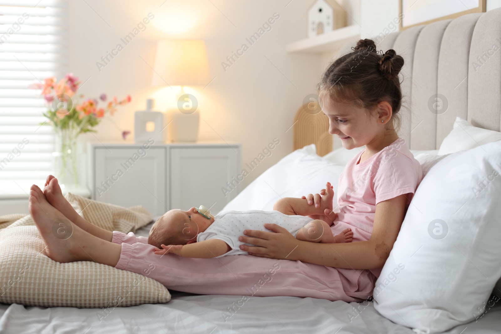 Big sister with newborn baby on bed at home. Space for text Photo of Big sister with newborn baby on bed at home. Space for text