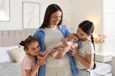 Photo of Mother with her daughters and newborn baby at home