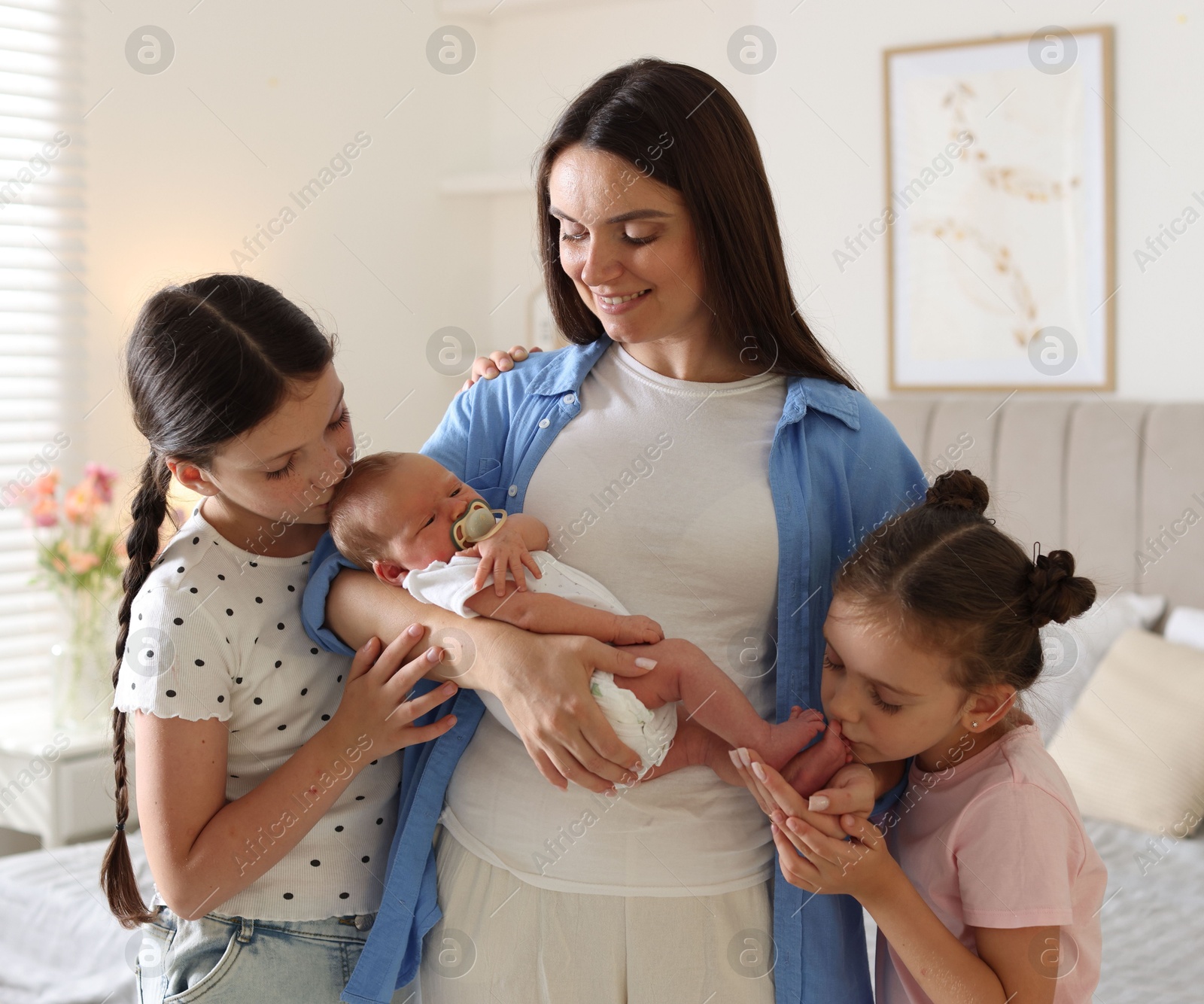 Mother with her daughters and newborn baby at home Photo of Mother with her daughters and newborn baby at home