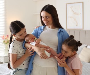 Photo of Mother with her daughters and newborn baby at home