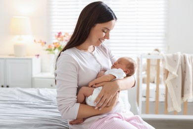 Photo of Mom with her newborn baby on bed at home