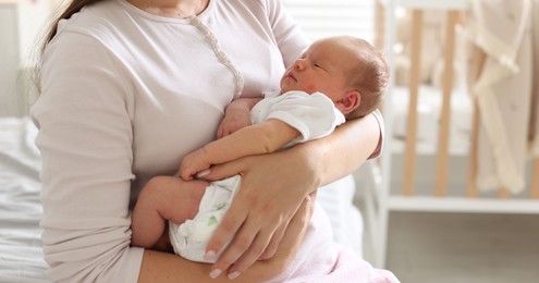 Photo of Mom with her newborn baby at home, closeup