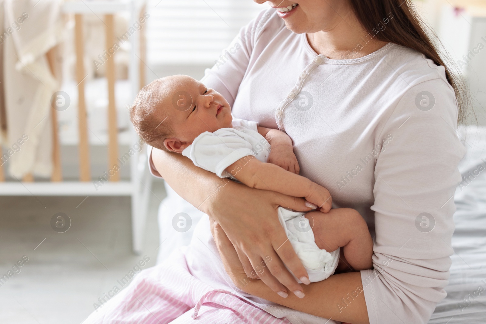 Photo of Mom with her newborn baby at home, closeup