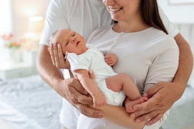 Photo of Happy parents with their newborn baby at home, closeup