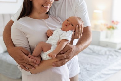 Photo of Happy parents with their newborn baby at home, closeup