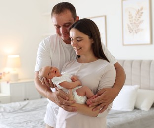 Photo of Happy parents with their newborn baby at home