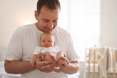 Photo of Dad with his newborn baby at home