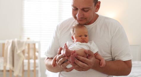 Photo of Dad with his newborn baby at home, closeup