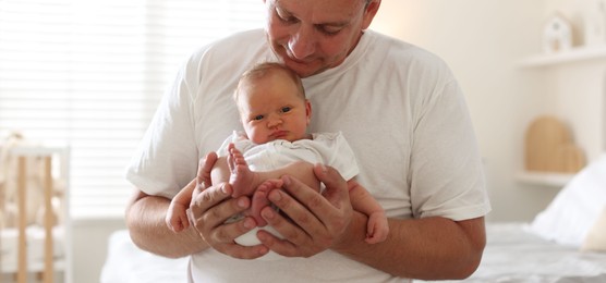 Photo of Dad with his newborn baby at home, closeup