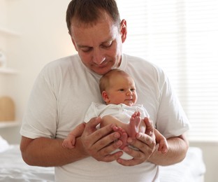 Photo of Dad with his newborn baby at home