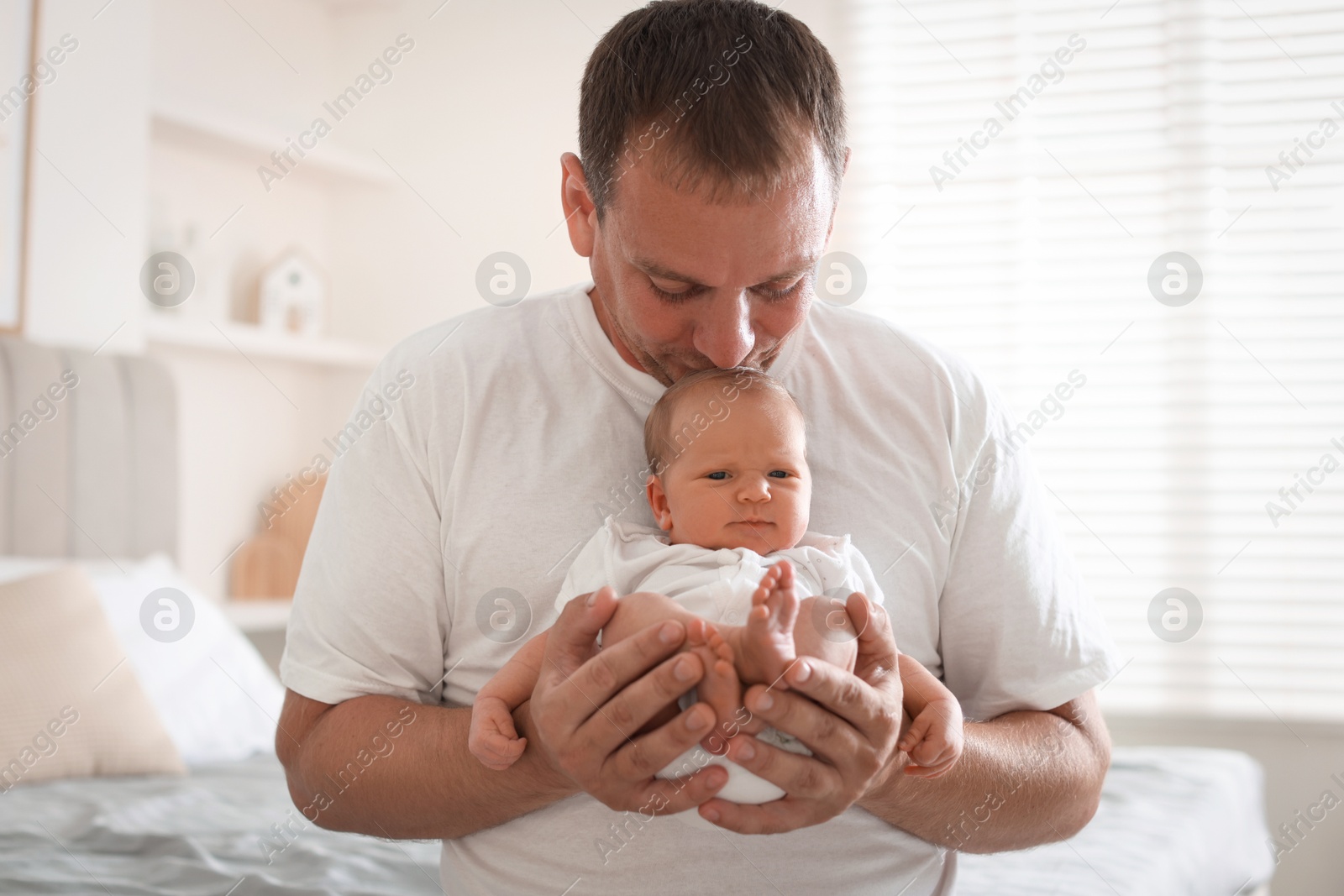 Dad kissing his newborn baby at home Photo of Dad kissing his newborn baby at home