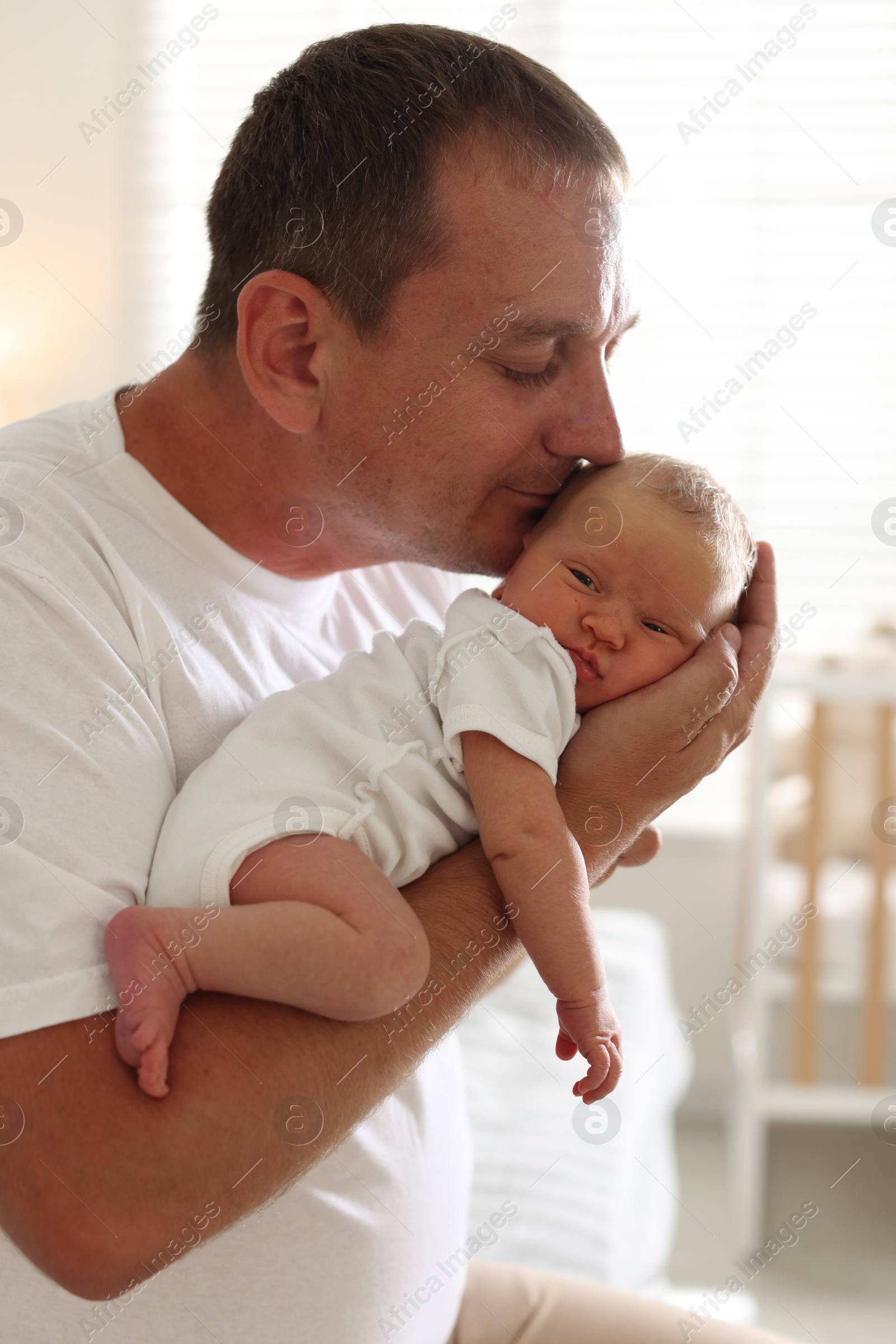 Dad kissing his newborn baby at home Photo of Dad kissing his newborn baby at home