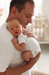 Photo of Father with his newborn baby at home