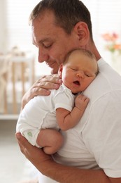 Photo of Father with his newborn baby at home