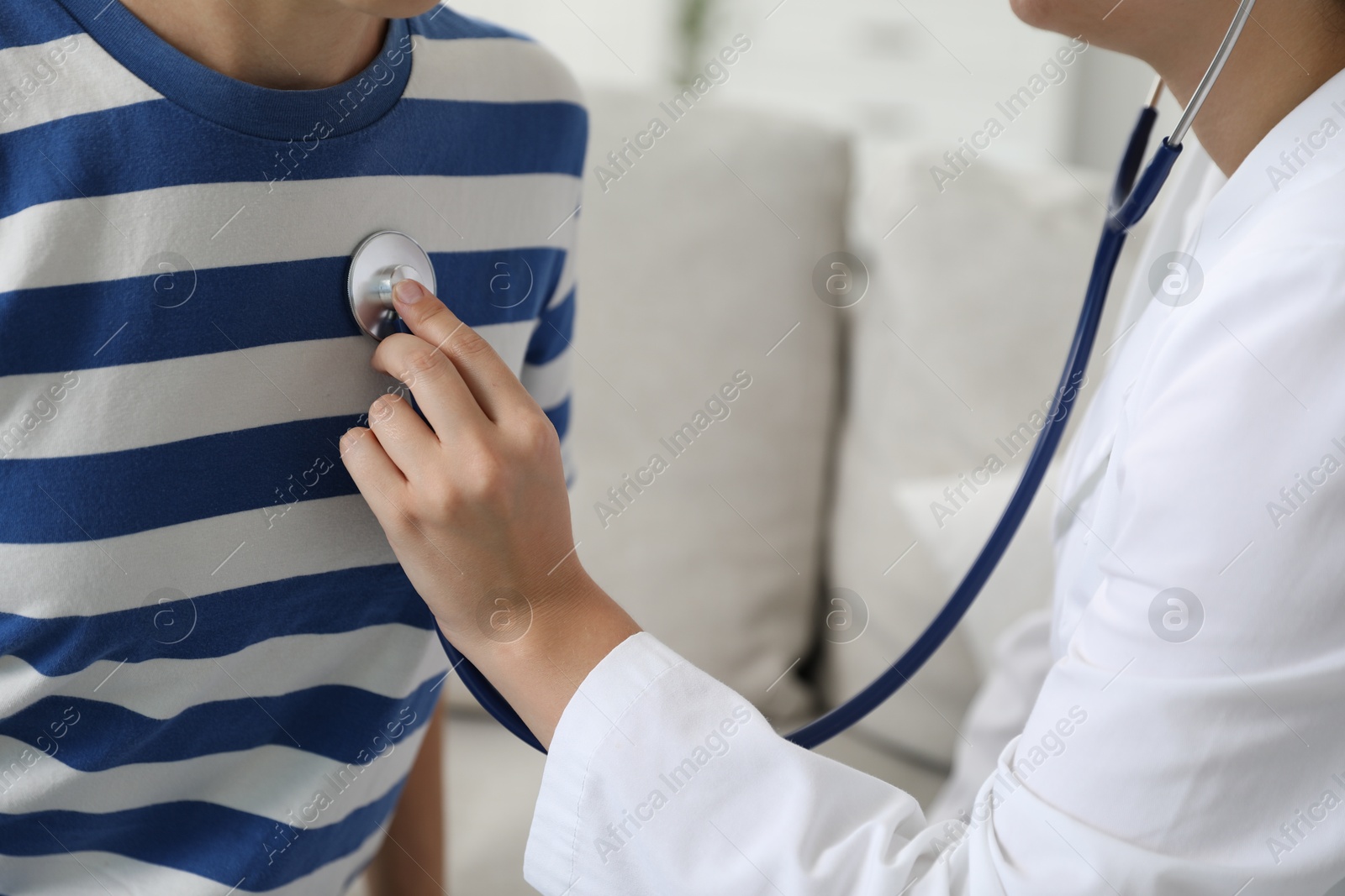 Photo of Doctor checking woman's heartbeat with stethoscope indoors, closeup