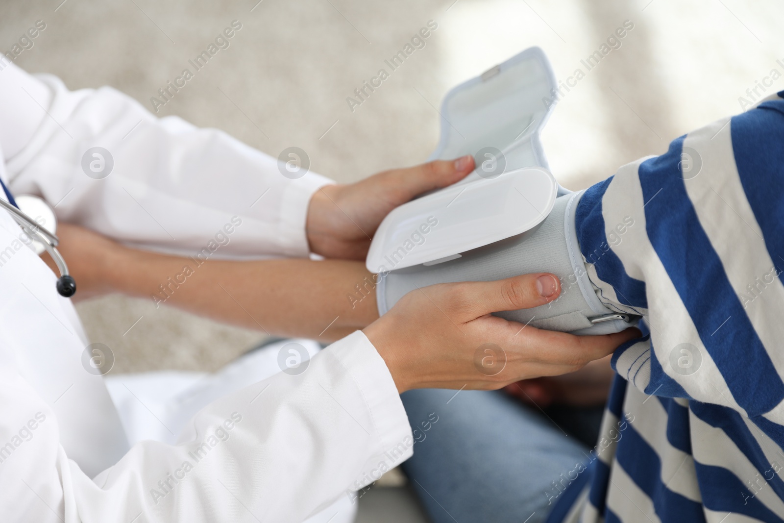 Photo of Doctor checking woman's heart rate and blood pressure via sphygmomanometer indoors, closeup