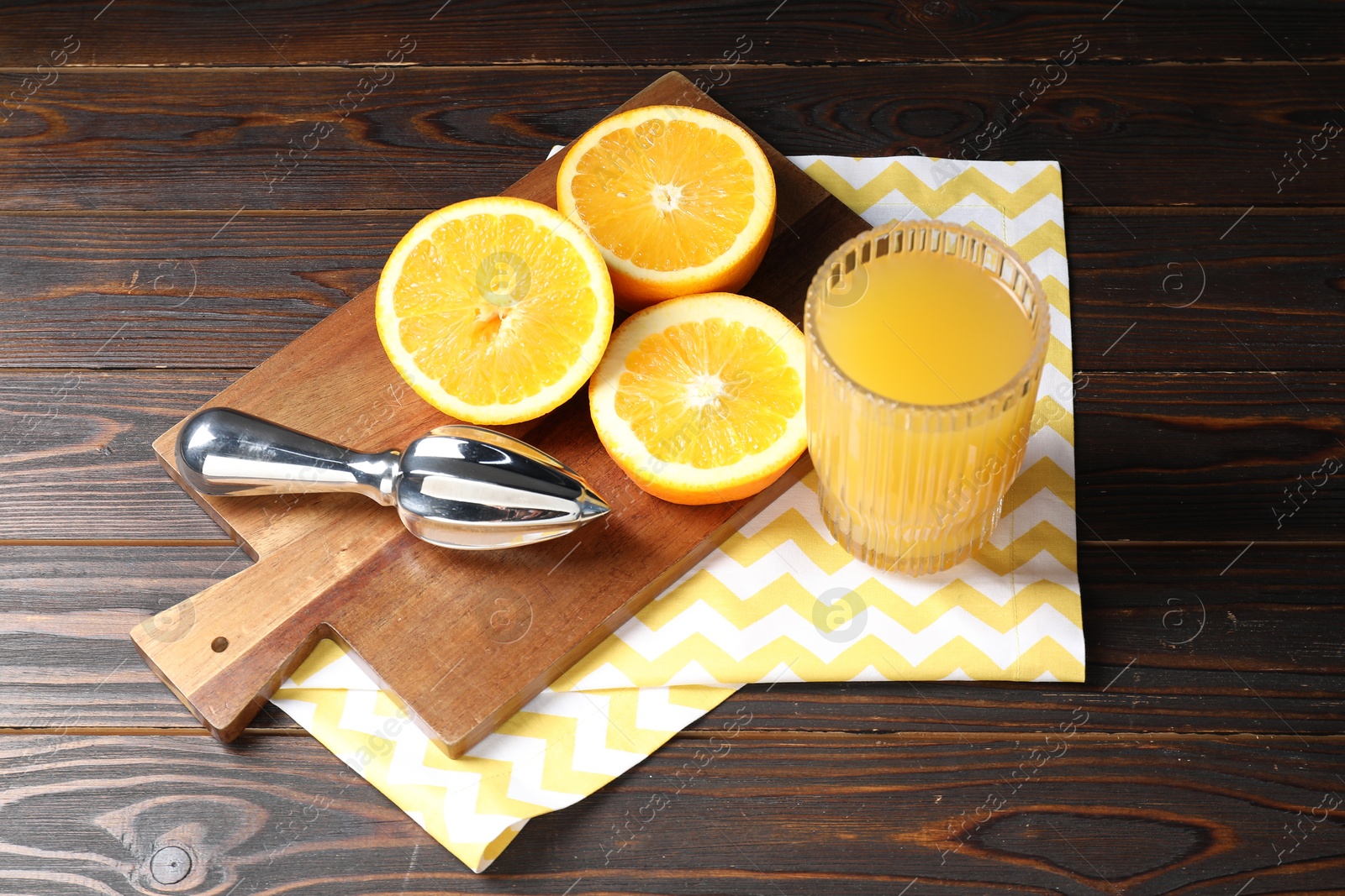 Photo of Freshly squeezed orange juice, fruits and juicer on wooden table
