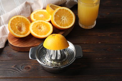Photo of Freshly squeezed orange juice, fruits and juicer on wooden table