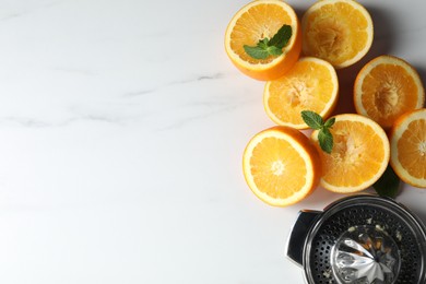Photo of Squeezer, oranges and mint on white table, flat lay with space for text. Making fresh juice