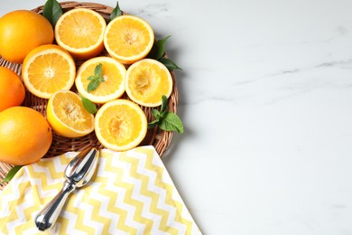Photo of Squeezer, oranges and mint on white table, flat lay with space for text. Making fresh juice