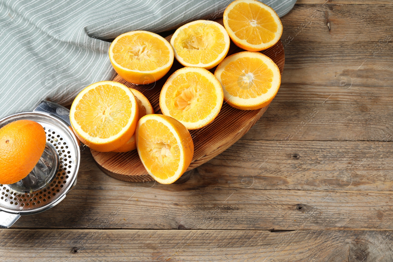 Squeezer and oranges on wooden table, flat lay with space for text. Making fresh juice Photo of Squeezer and oranges on wooden table, flat lay with space for text. Making fresh juice