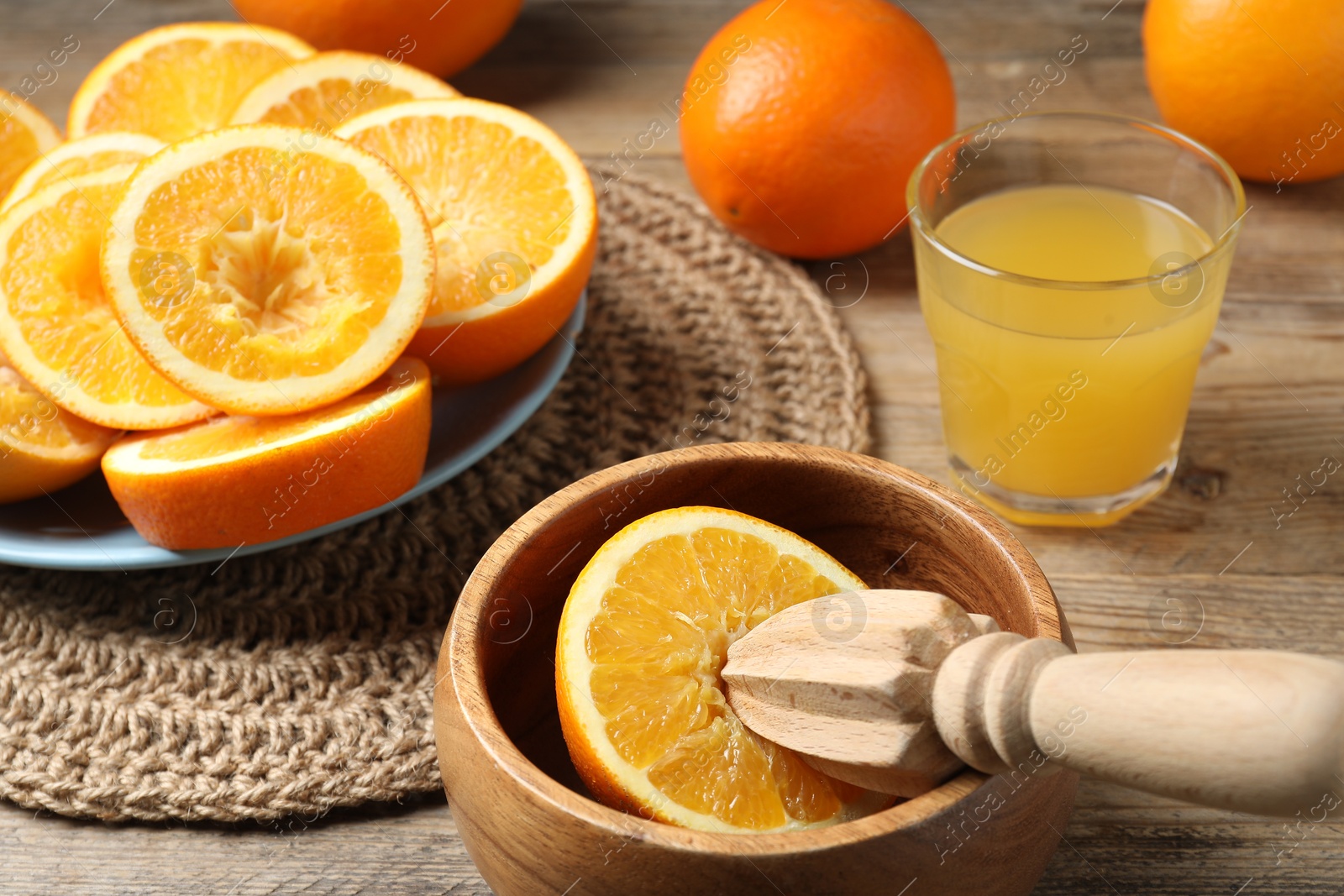 Freshly squeezed orange juice, fruits and juicer on wooden table, closeup Photo of Freshly squeezed orange juice, fruits and juicer on wooden table, closeup