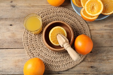 Photo of Freshly squeezed orange juice, fruits and juicer on wooden table, flat lay