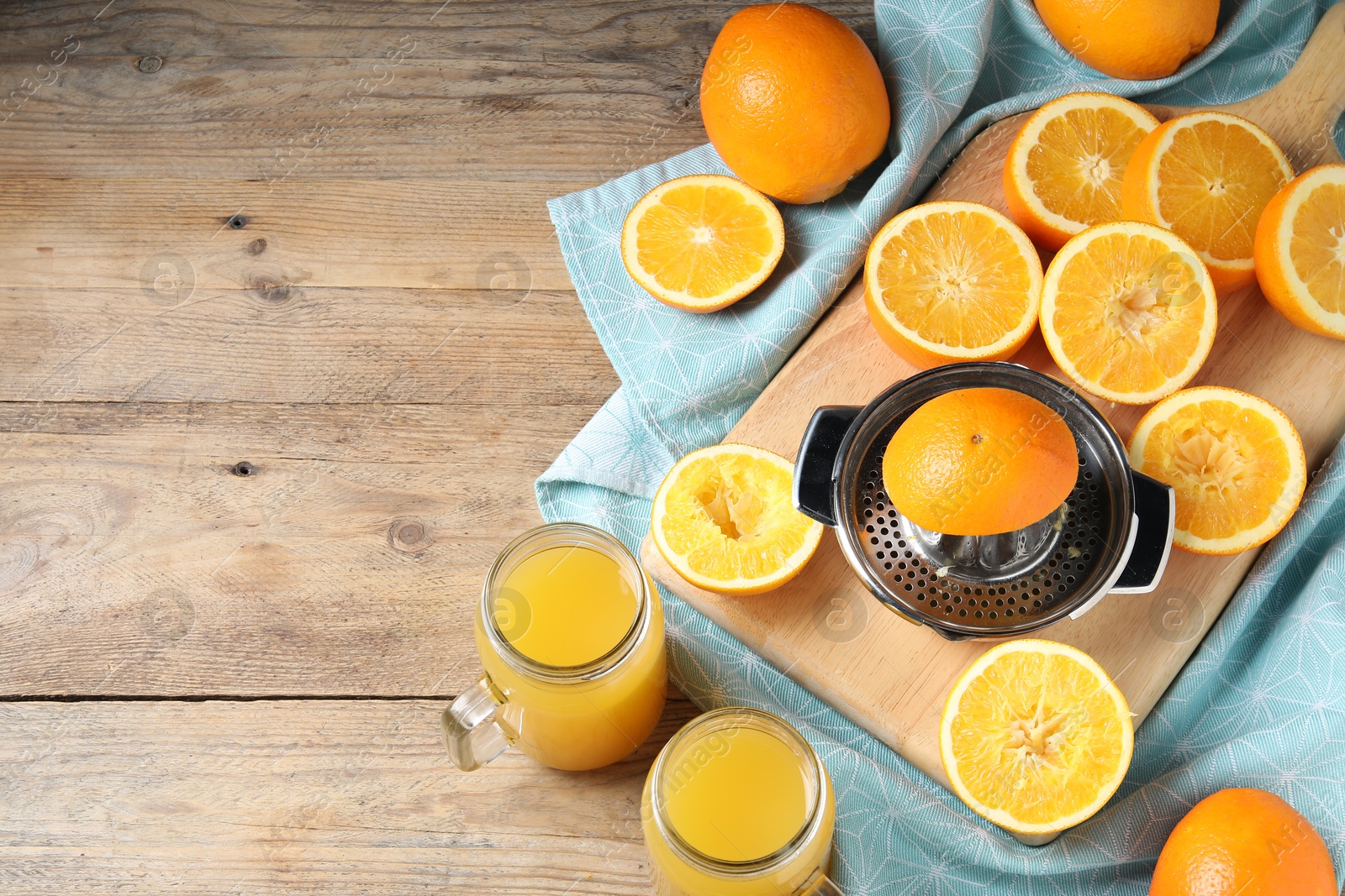 Freshly squeezed orange juice, fruits, juicer and towel on wooden table, flat lay. Space for text Photo of Freshly squeezed orange juice, fruits, juicer and towel on wooden table, flat lay. Space for text
