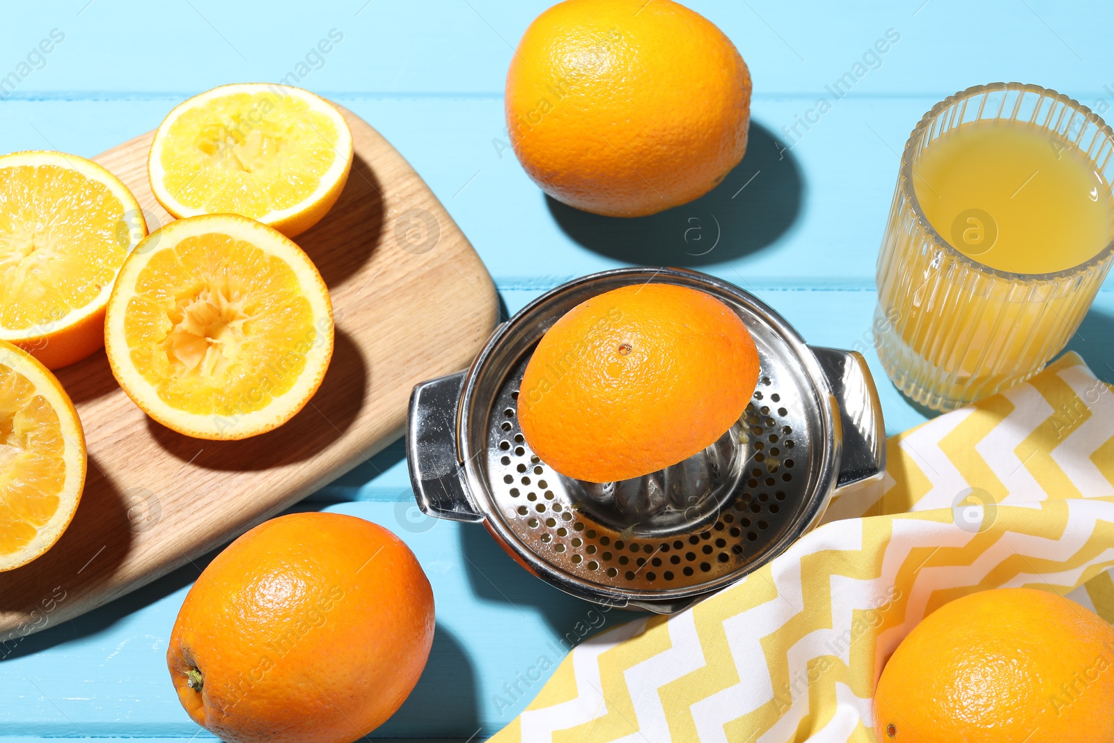 Freshly squeezed orange juice, fruits and juicer on blue wooden table, closeup Photo of Freshly squeezed orange juice, fruits and juicer on blue wooden table, closeup
