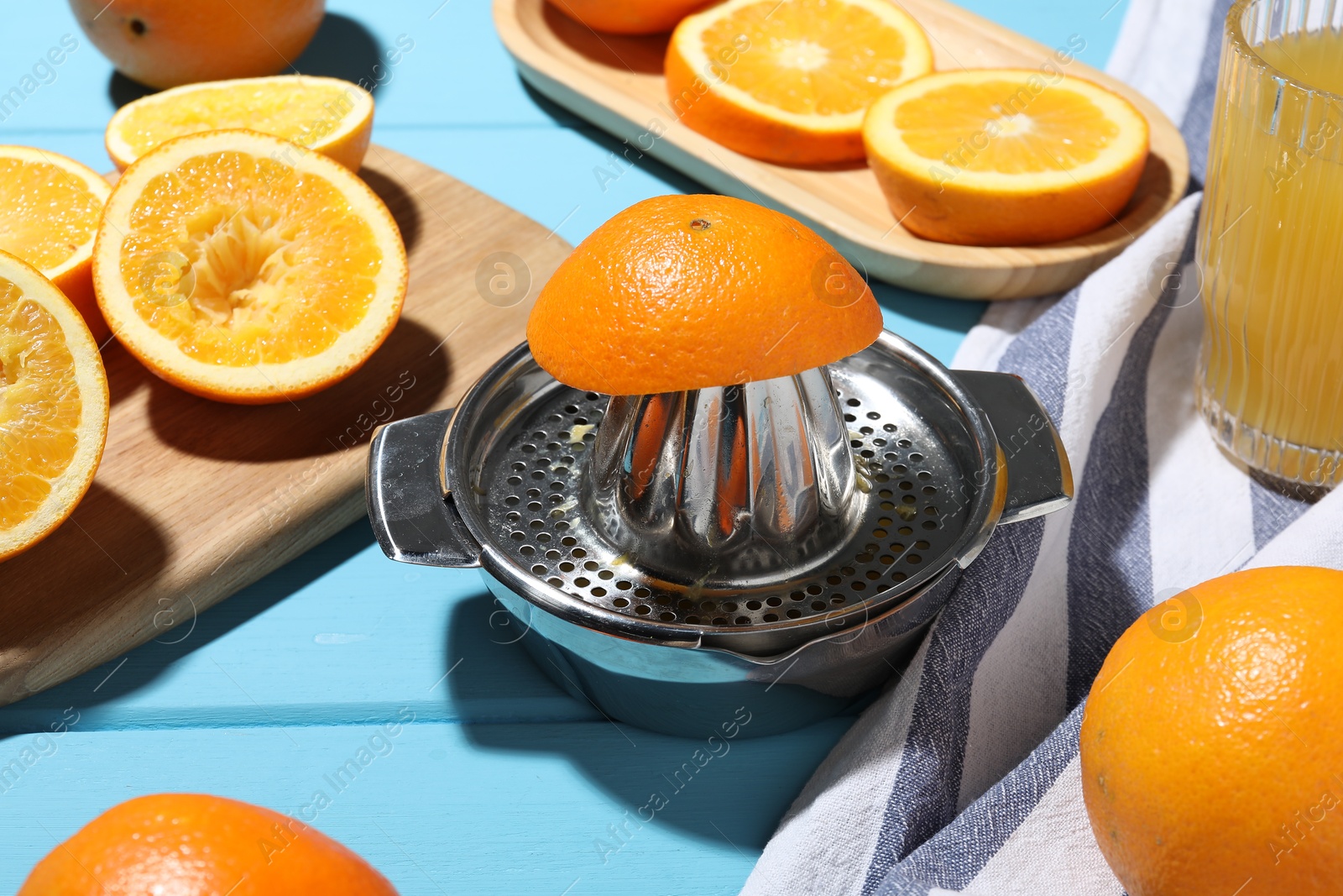 Squeezer, oranges and fresh juice on blue wooden table, closeup Photo of Squeezer, oranges and fresh juice on blue wooden table, closeup