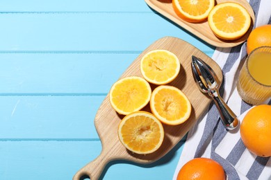 Photo of Squeezer, oranges and fresh juice on blue wooden table, flat lay. Space for text