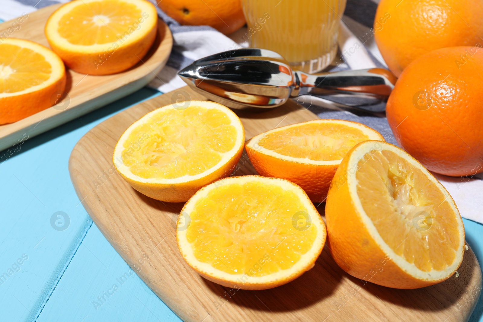 Oranges and squeezer on blue wooden table, closeup. Making fresh juice Photo of Oranges and squeezer on blue wooden table, closeup. Making fresh juice