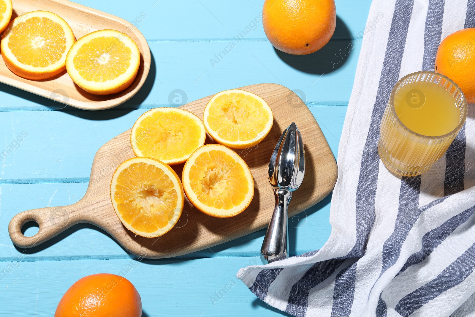 Squeezer, oranges and fresh juice on blue wooden table, above view Photo of Squeezer, oranges and fresh juice on blue wooden table, above view