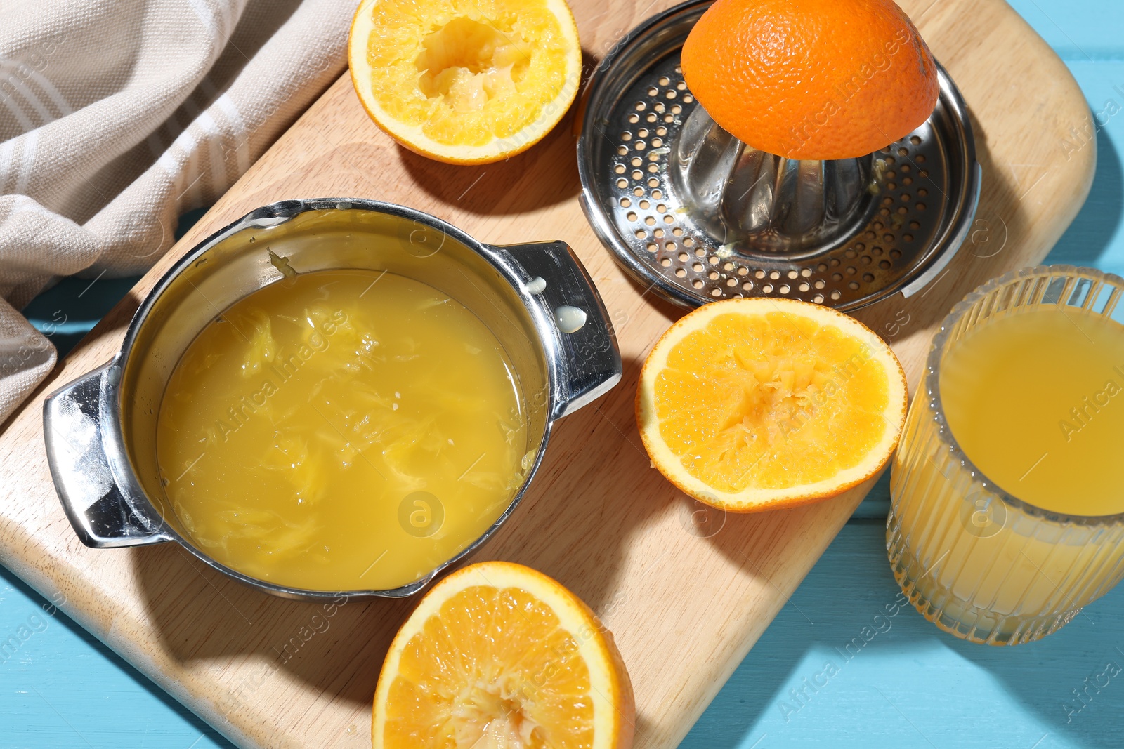 Freshly squeezed orange juice, fruits and juicer on blue wooden table, closeup Photo of Freshly squeezed orange juice, fruits and juicer on blue wooden table, closeup