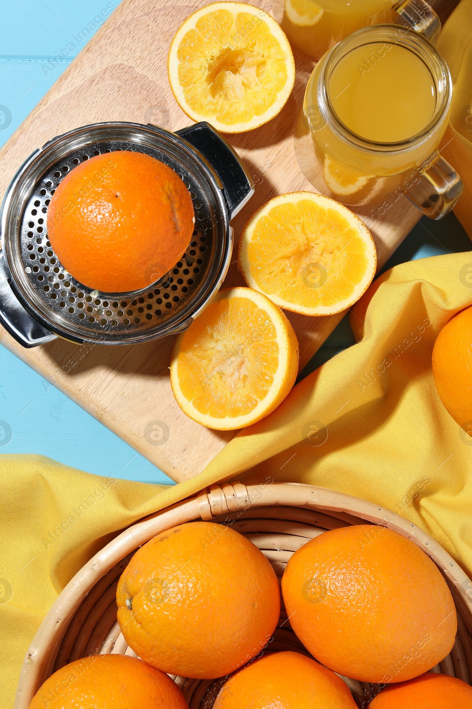 Freshly squeezed orange juice, fruits, juicer and towel on blue wooden table, flat lay Photo of Freshly squeezed orange juice, fruits, juicer and towel on blue wooden table, flat lay