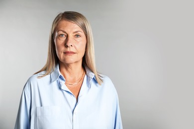Photo of Portrait of beautiful senior woman on light background. Space for text